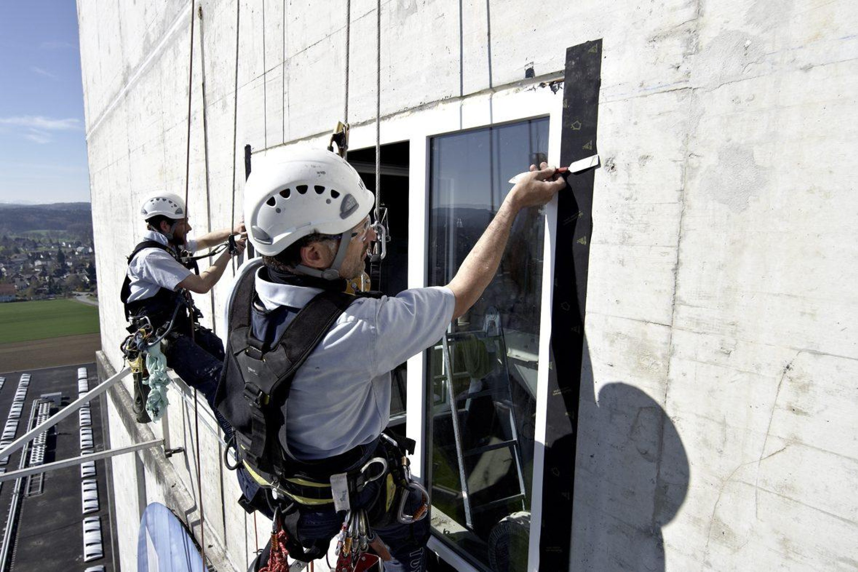 Industriekletterer beim Einglasen  – Toprope